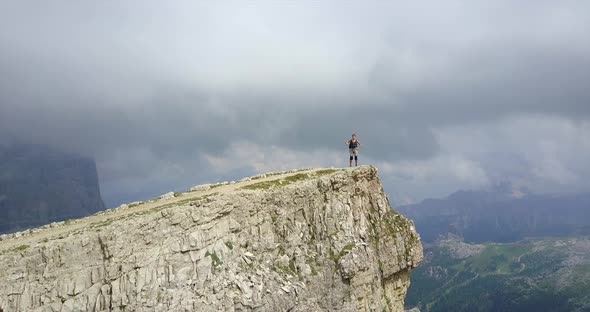 Aerial drone view of a woman hiking in the mountains.