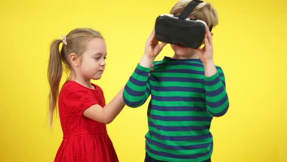 Cute Caucasian Girl Pulling Hand of Absorbed Boy in VR Headset