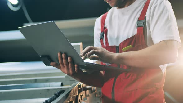 Industrial Conveyor and a Male Engineer Holding a Laptop