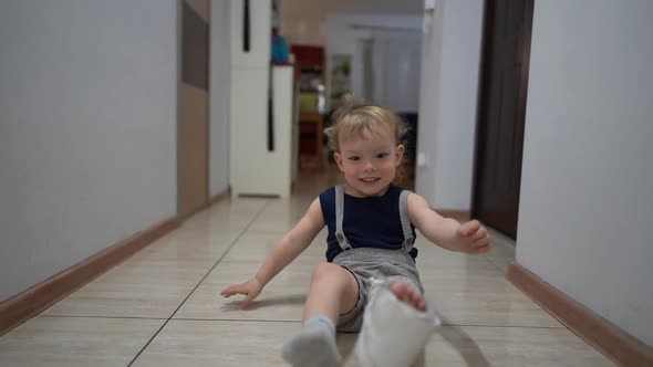 Happy Cute Toddler After an Accidental Fracture of His Leg Moves Around the Apartment with a Plaster