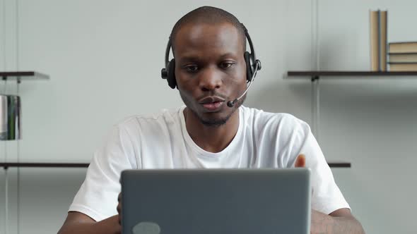 A Smiling Black Man in a Headset Learns a Foreign Language Using a Video Call