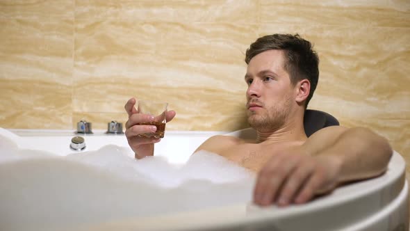 Nervous Businessman Trying to Relax Taking Aroma Bathtub and Drinking Rum