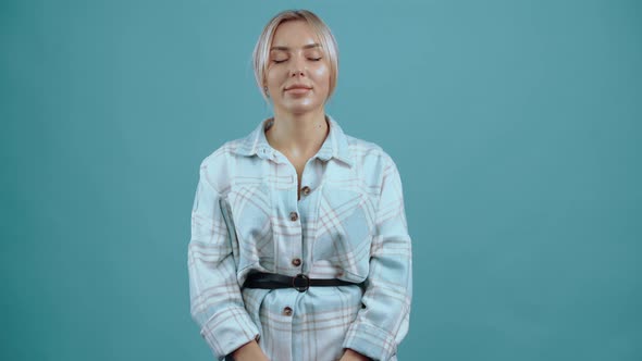 Blonde Young Woman with Closed Eyes Tired but Smiling a Little