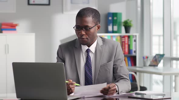 AfricanAmerican Lawyer Having Online Meeting with Client Using Laptop