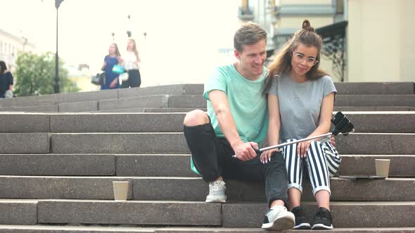 Couple Posing for Camera Sitting Outdoors