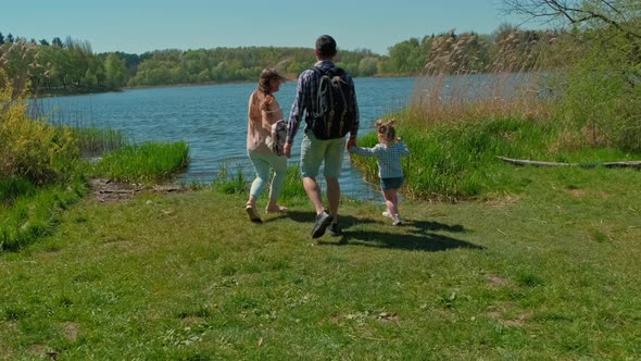 Happy Cute Family Walking in Nature Park By Lake