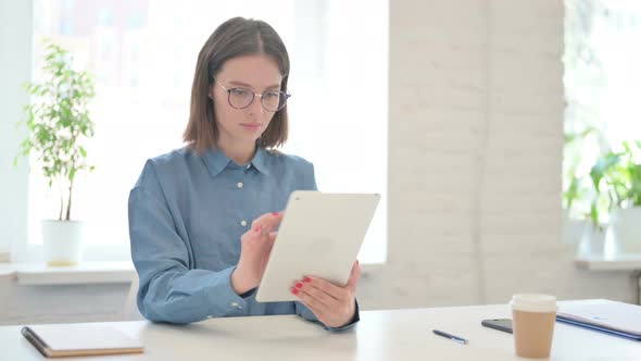 Attractive Young Woman using Tablet in Office