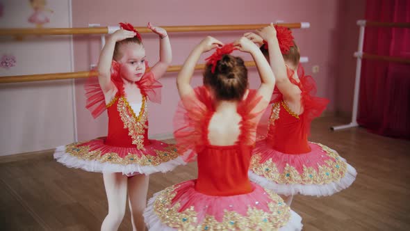 Little Girls in Red Dresses Dance Ballet Dance in a Circle