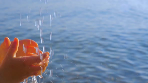 Kids Hands Reaching Out the Drops of the Water. Water Pouring From the Top on Little Childs Hands