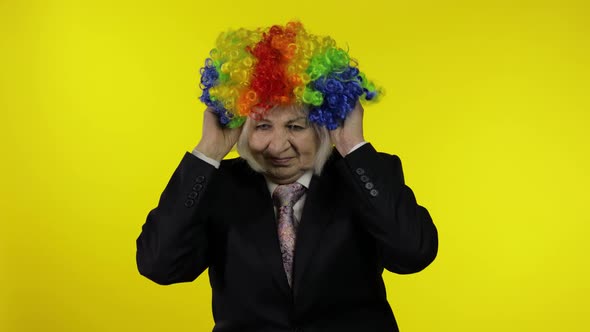 Senior Female Woman in Business Suit Wears Clown Wig, Begin Working and Smiling