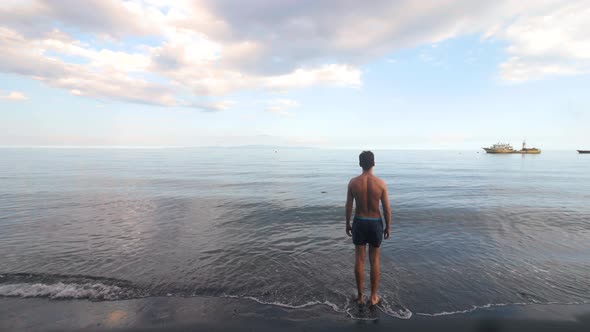 Masculine Man Standing and Walking at the Beach on Summer Day.