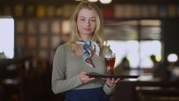 Confident Caucasian Smiling Woman Posing with Beer Glass on Tray in Pub