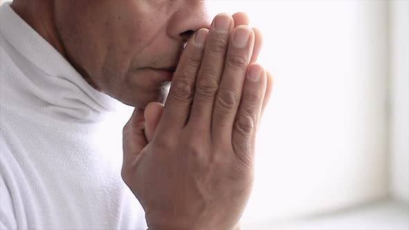 man praying to god with hands together Caribbean man praying with grey background stock video stock