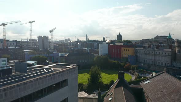 Rising Shot of Town Development and Group of Tower Cranes on Construction Site in Background