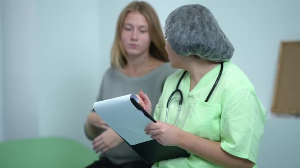 Side View Positive Obstetrician Writing with Pen Filling in Medical History