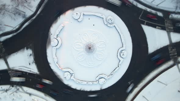 Aerial View of Roundabout Road with Circular Cars in Snow Covered Small European City at Winter Day