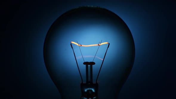 Closeup Incandescent Lamp Flashes on a Dark Background