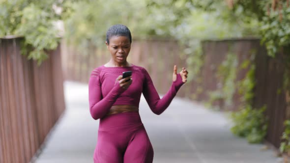African American Sports Black Female Jogger Girl in Sportswear Receives Phone Call While Jogging
