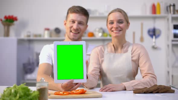 Couple Holding Tablet With Green Screen, Showing Thumbs Up, Delicious Recipe App