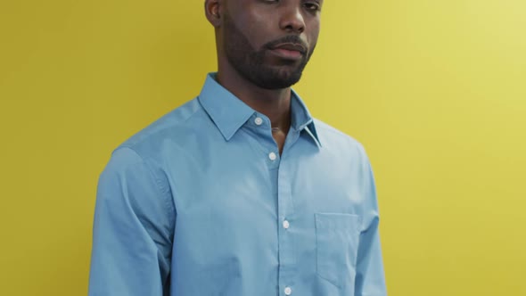 Video of smiling african american man looking at camera on yellow background