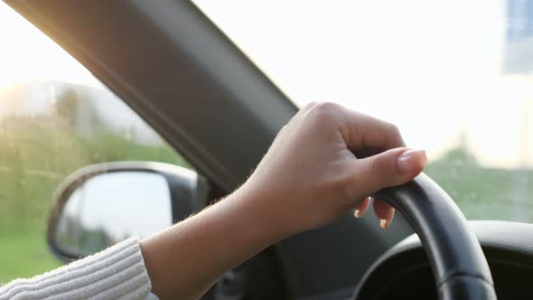 Close-up of Woman's Hands on the Steering Wheel of a Car