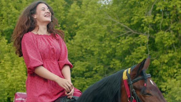 Young Smiling Woman with Braces in Pink Dress Riding a Horse