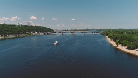 White Cruise Ship Floats Along River Near Beautiful Modern Bridge.