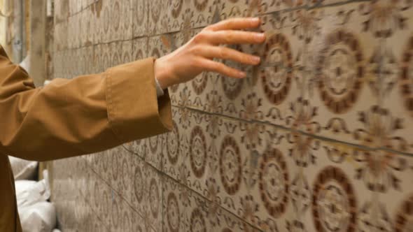 Woman Walks Along Lisbon Street Touching Azulejo Tiles