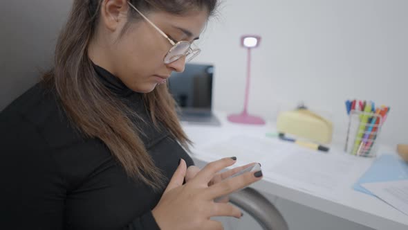 Close Up Shot of a Young Student Sitting on a Chair and Useing Her Phone alt