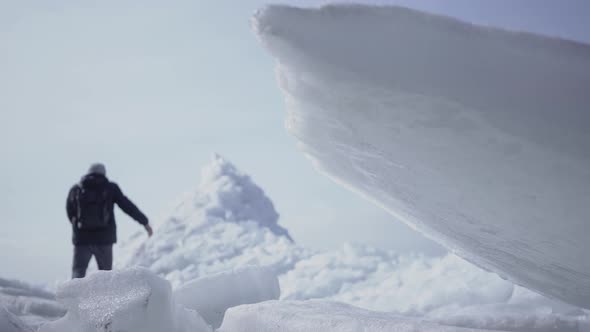 The Male Tourist on the Background Climbing on the Top of the Glacier