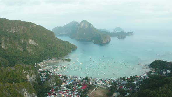 WS AERIAL View of coastal city, cliffs, harbor with boats and sea, El Nido, Palawan, Philippines