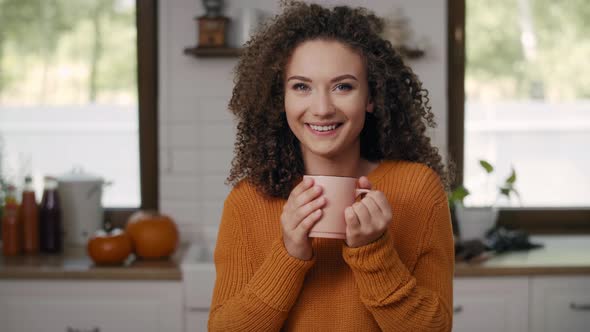 Portrait of smiling young woman drinking hot tea