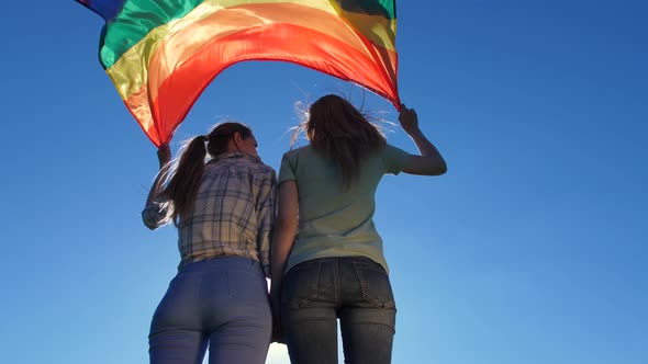 Young Lesbians with Flag Standing Back Outdoor