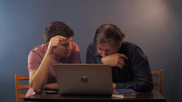 Man Talks with Tied Father Explaining How To Works on Laptop