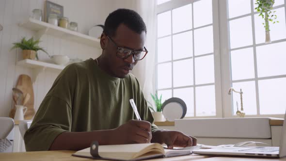 African American Man Counts Total Amount of Money on Checks