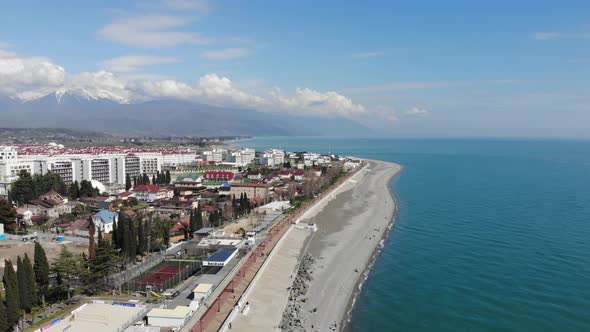 Aerial View of Adler, Sochi Beach, Town and Mountains. Waterfront Stretches Across the Coastline in