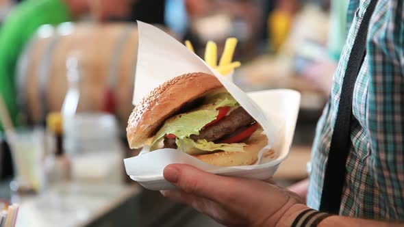 Man Holding Fresh Gamburger and Fries