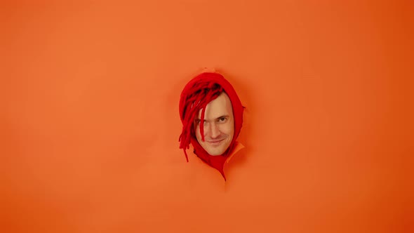 Smiling Man with Red Dreadlocks in Hole in Wall