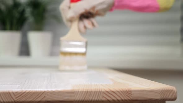 Woman Painting Wooden Table in White Color