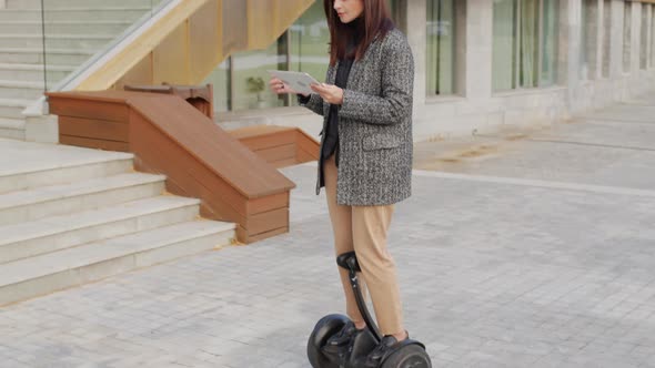 Business Lady With Digital Tablet Riding Gyrocooter