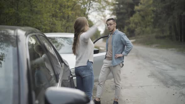 Young Stressed Man and Woman Yelling and Gesturing on Roadside