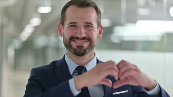 Portrait of Happy Businessman Showing Heart Sign with Hand