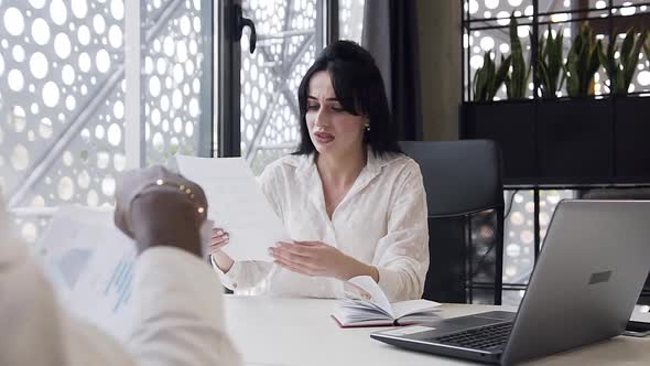 Businesswoman Looking at Financial Report with Diagram and Transmiting it to Her Business Partner