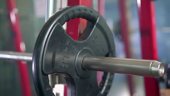 Focused Shot of Man's Hands Adding 3 Plates on a Barbell