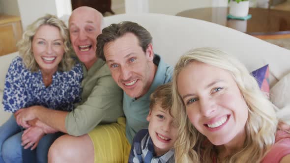 Portrait of happy caucasian family taking selfie in living room