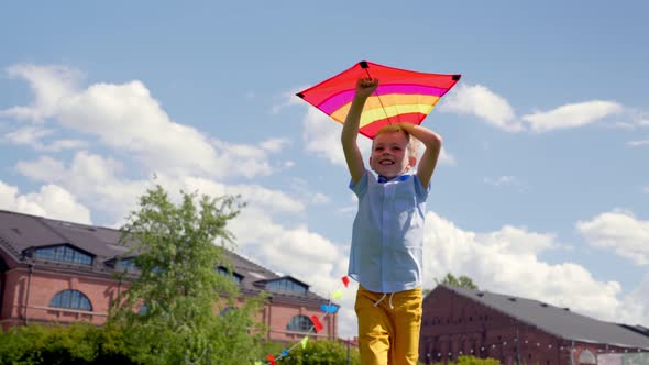 Slider Shot of Little Boy Running with Kite in Summer Park
