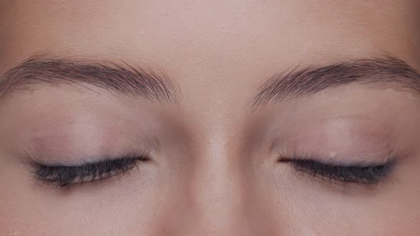 Close-up portrait of young, beautiful and natural woman opening her eyes.