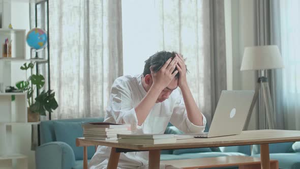 Asian Man Student Being Tired While Typing On Computer At Home