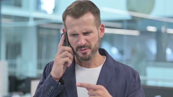 Angry Middle Aged Businessman Talking on Smartphone