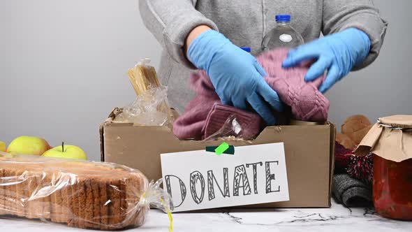 woman in a gray sweater puts various things and food 